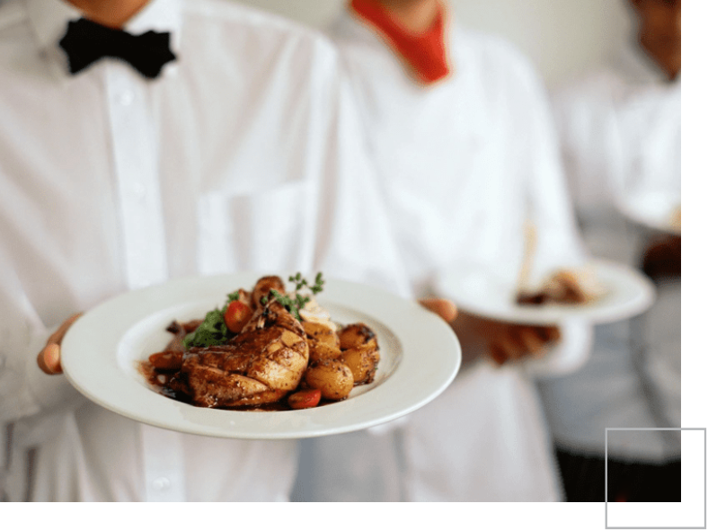 A couple of chefs holding plates with food on them.