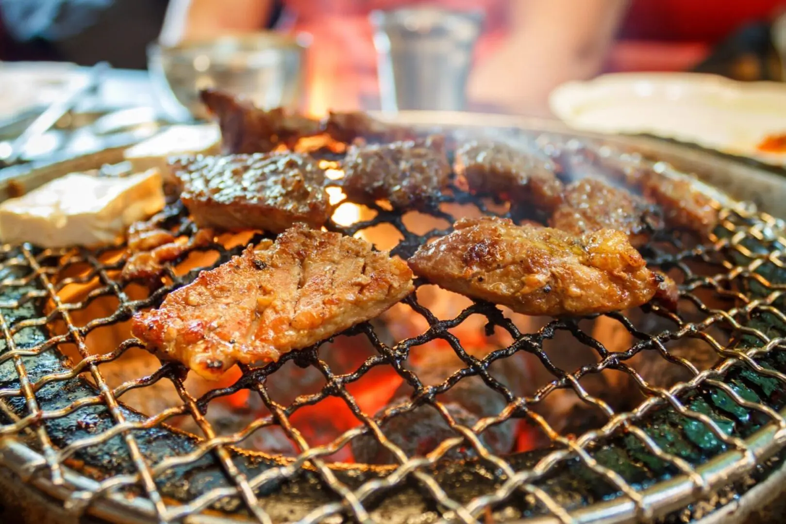 A grill with several different types of meat on it.