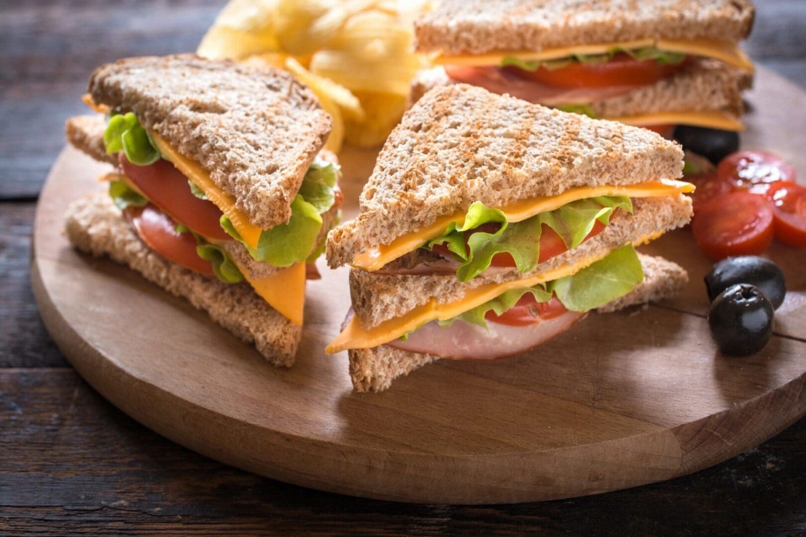 A sandwich cut in half on top of a wooden board.