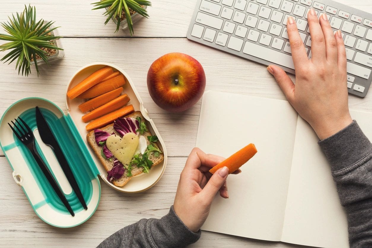 A person is writing on an orange pencil.